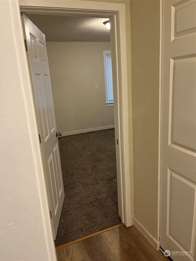 hallway with dark hardwood / wood-style flooring