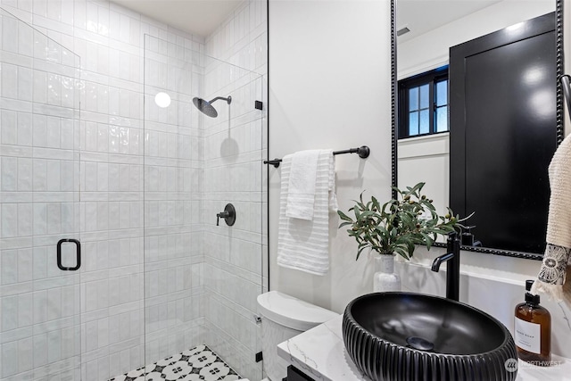 bathroom featuring sink, an enclosed shower, and toilet