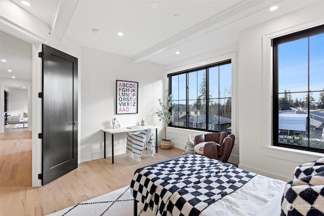 bedroom with beamed ceiling and hardwood / wood-style flooring