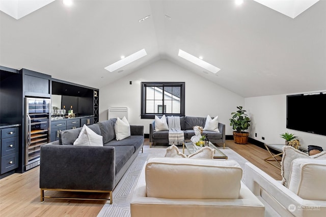 living room with lofted ceiling with skylight and light wood-type flooring