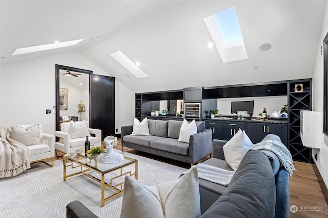 living room with vaulted ceiling with skylight and light wood-type flooring