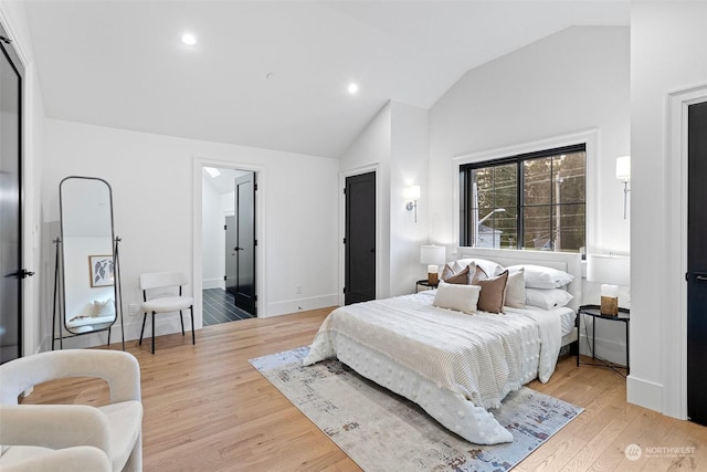 bedroom with vaulted ceiling and light hardwood / wood-style floors