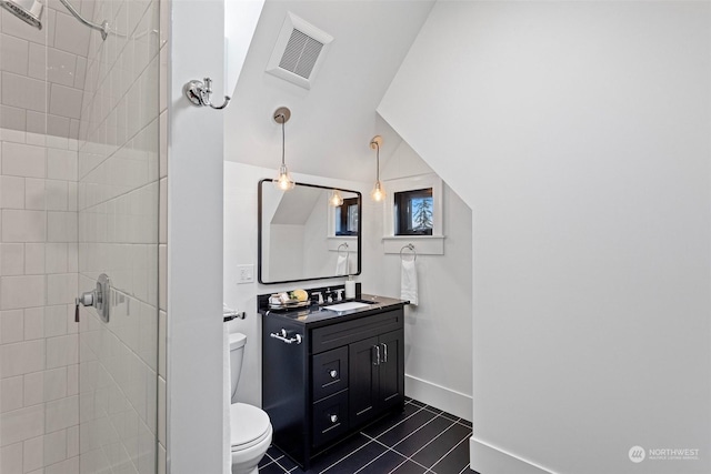 bathroom featuring tiled shower, tile patterned floors, toilet, and vanity