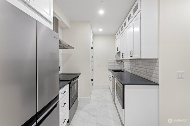 kitchen featuring sink, tasteful backsplash, range with electric stovetop, stainless steel fridge, and white cabinets