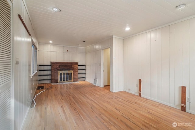 unfurnished living room featuring a brick fireplace and light hardwood / wood-style flooring