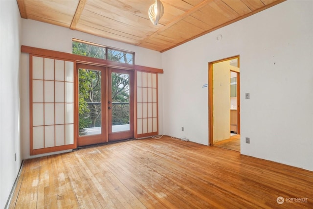 unfurnished room featuring wood ceiling, light hardwood / wood-style floors, and french doors