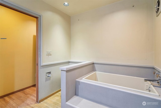 bathroom featuring hardwood / wood-style flooring and a bathing tub