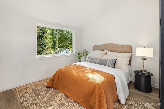 bedroom featuring lofted ceiling and hardwood / wood-style floors