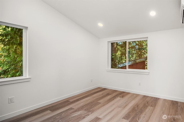 empty room featuring lofted ceiling and light hardwood / wood-style floors