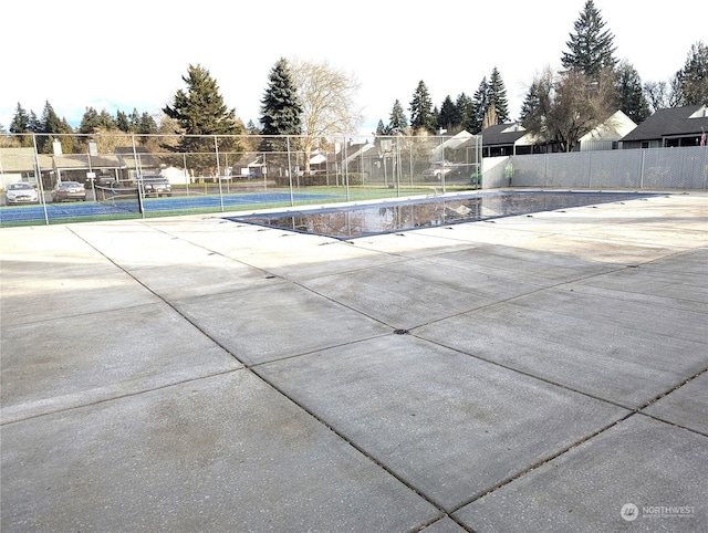 view of swimming pool featuring tennis court