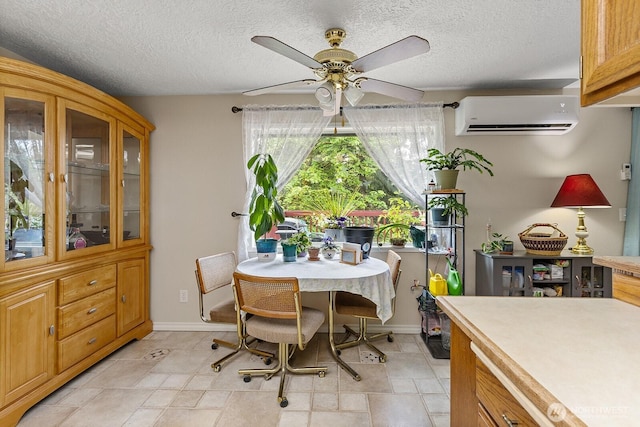 dining area featuring a ceiling fan, a textured ceiling, baseboards, and a wall mounted air conditioner