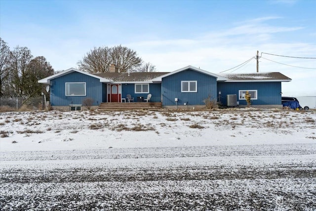 snow covered property with central air condition unit