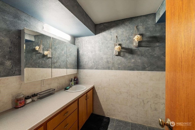 bathroom with vanity and tile walls