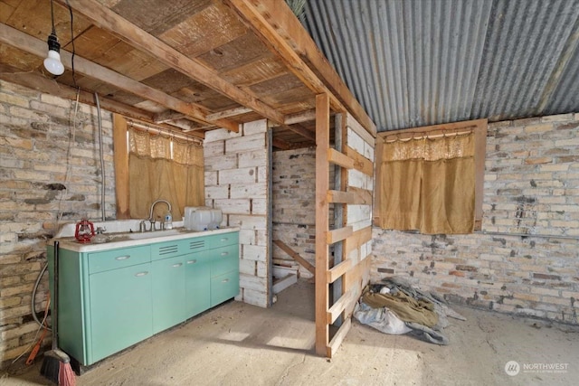 misc room featuring brick wall and sink