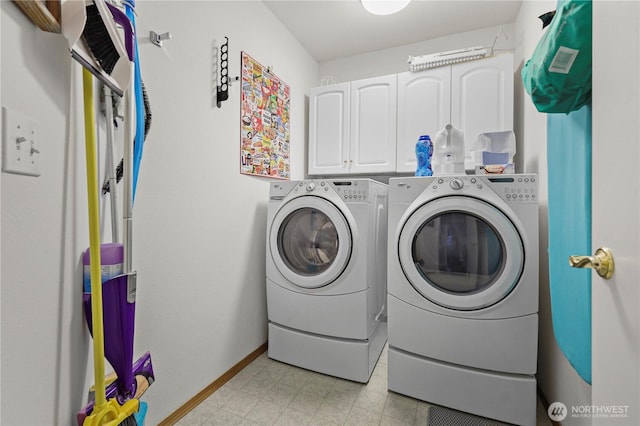 clothes washing area with cabinets and washer and clothes dryer