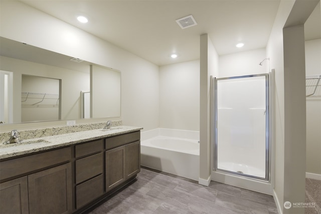 bathroom featuring shower with separate bathtub and vanity