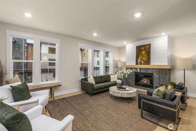 living area featuring a fireplace, baseboards, wood finished floors, and recessed lighting