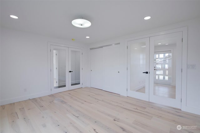 empty room with light hardwood / wood-style flooring and french doors