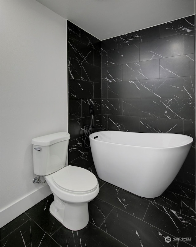 bathroom featuring a tub to relax in and toilet