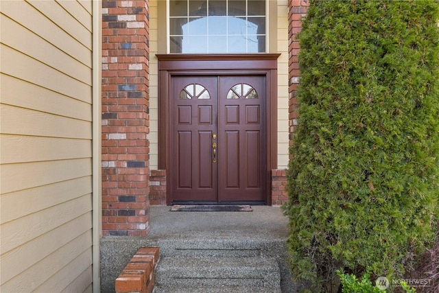 entrance to property featuring brick siding