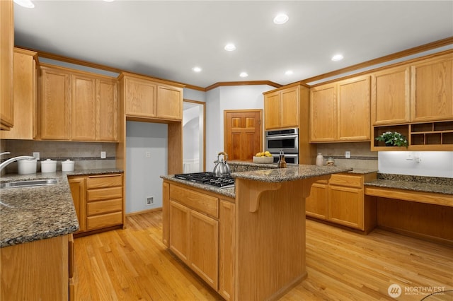 kitchen with light wood-style flooring, a center island, a sink, dark stone countertops, and stainless steel appliances