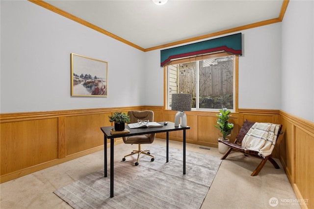 office area featuring a wainscoted wall, visible vents, light carpet, and ornamental molding