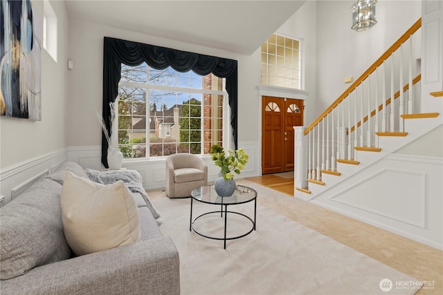 interior space with a wainscoted wall, stairway, and a decorative wall