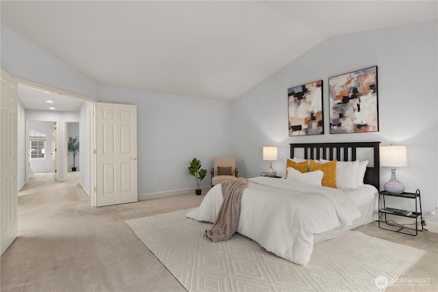 bedroom with vaulted ceiling, light colored carpet, and baseboards