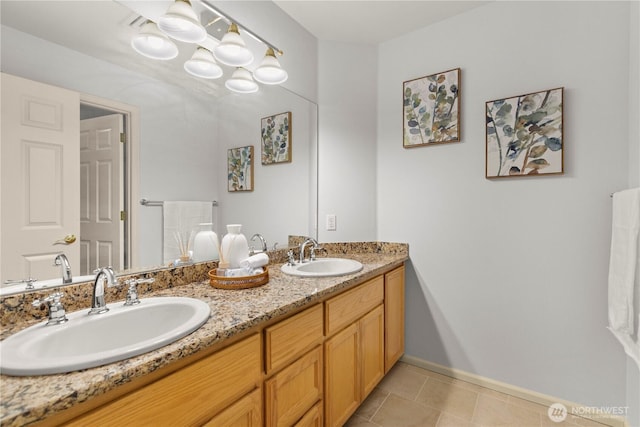 full bathroom featuring double vanity, baseboards, a sink, and tile patterned floors