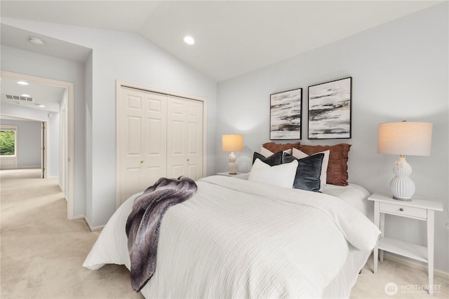 bedroom featuring visible vents, baseboards, light carpet, a closet, and lofted ceiling