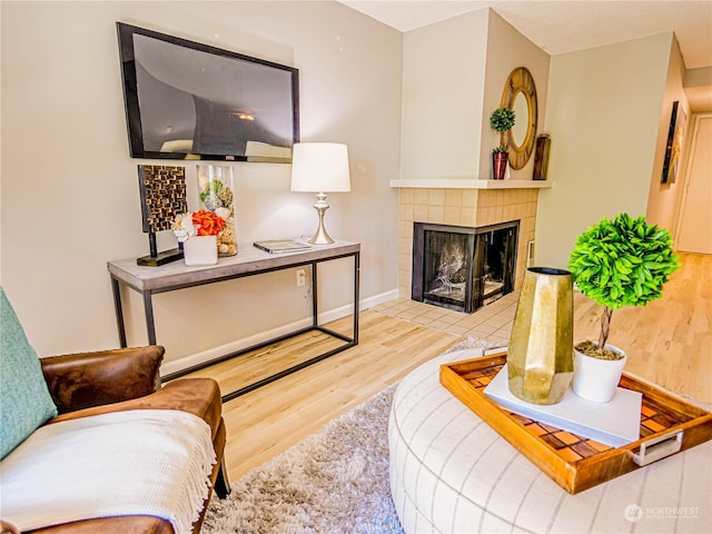 living room with hardwood / wood-style flooring and a tiled fireplace