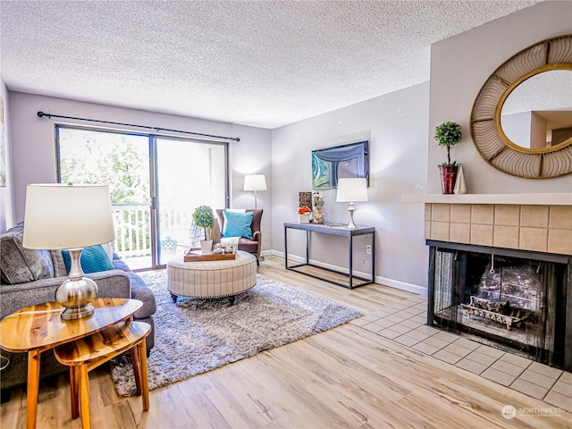 living room with hardwood / wood-style flooring, a textured ceiling, and a fireplace