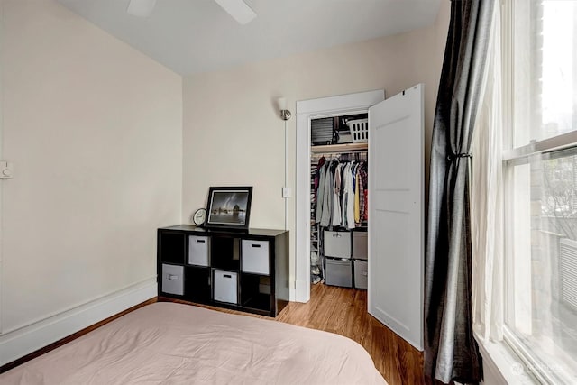 bedroom with ceiling fan, wood-type flooring, and a closet