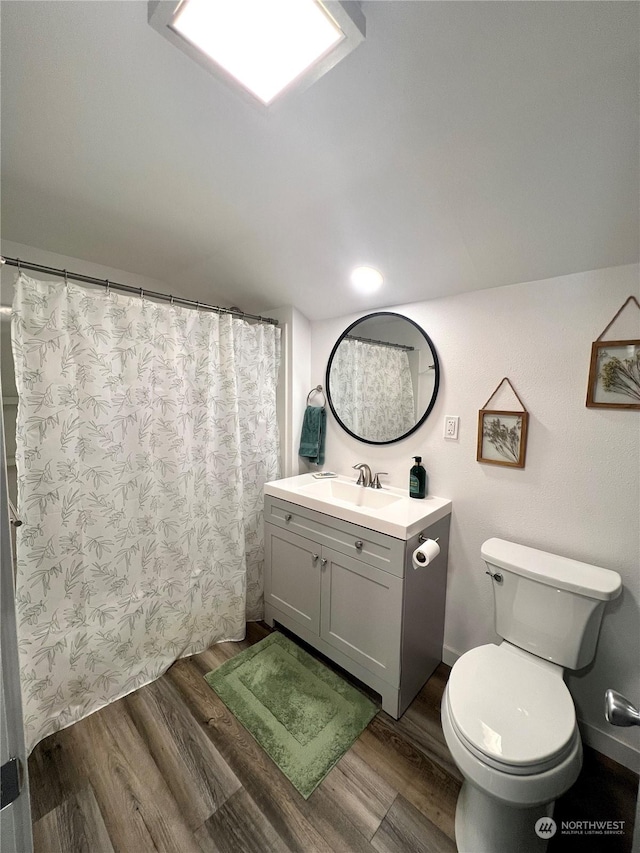 bathroom with vanity, toilet, and hardwood / wood-style floors