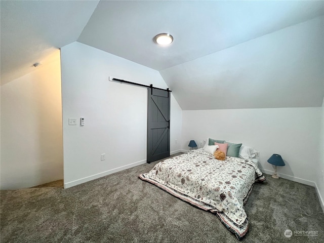 bedroom with lofted ceiling, a barn door, and dark colored carpet