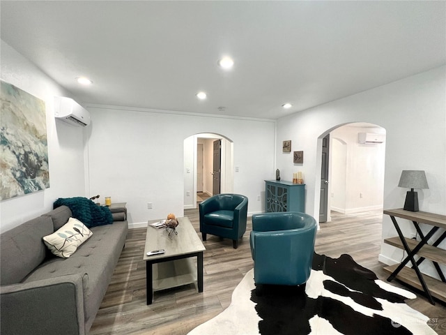 living room featuring hardwood / wood-style flooring and an AC wall unit