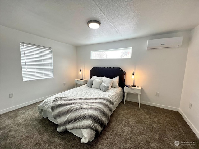 bedroom with a wall mounted AC, dark carpet, and a textured ceiling