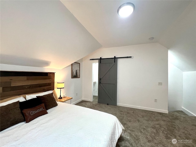 carpeted bedroom featuring lofted ceiling and a barn door