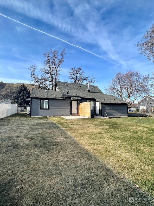 rear view of property featuring a patio area and a lawn