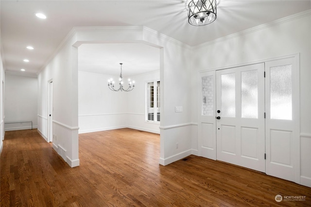 entryway featuring crown molding, hardwood / wood-style flooring, and a notable chandelier