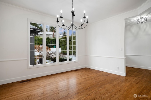 unfurnished dining area with an inviting chandelier, hardwood / wood-style flooring, plenty of natural light, and ornamental molding