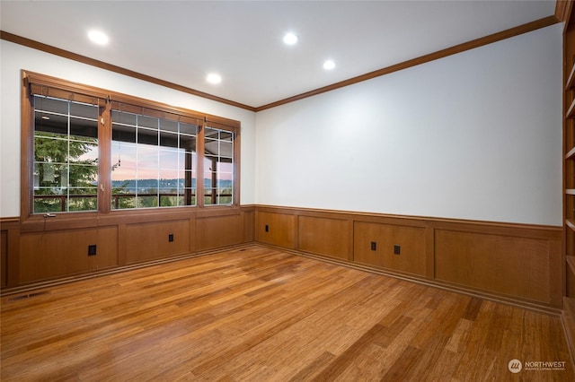 spare room featuring ornamental molding and light wood-type flooring