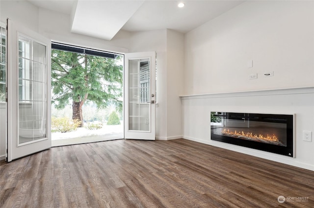 unfurnished living room featuring plenty of natural light and wood-type flooring