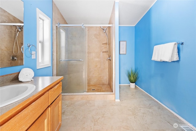 bathroom featuring a shower with door and vanity