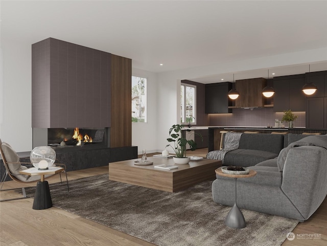 living area with light wood-type flooring and a large fireplace