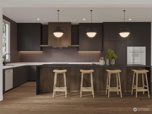 kitchen with white appliances, a sink, a kitchen breakfast bar, light wood-style floors, and tasteful backsplash