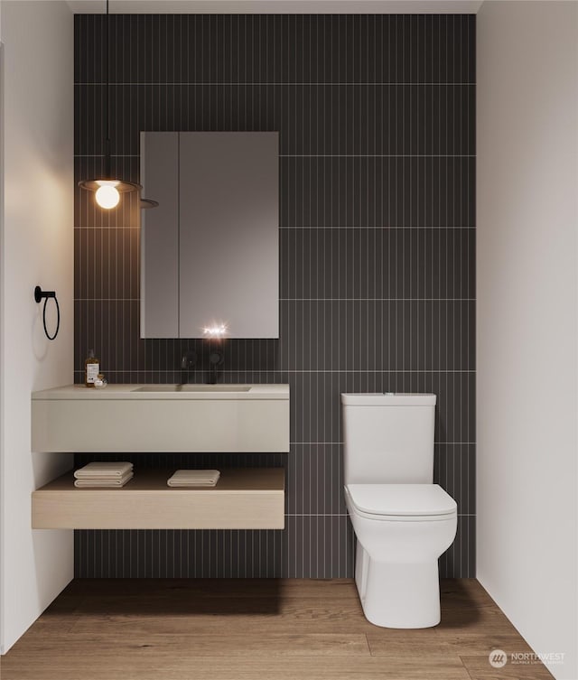 bathroom with vanity, wood finished floors, toilet, and tile walls