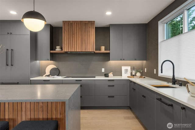 238 4th Ave Unit 100, Kirkland, WA 98033 - kitchen with gray cabinetry, open shelves, decorative backsplash, range hood, and light wood-style flooring