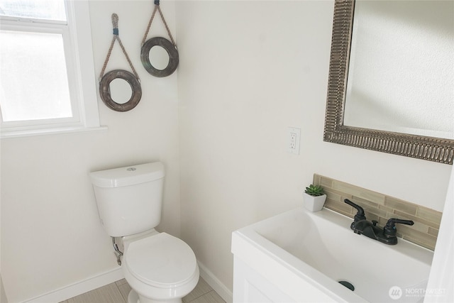 bathroom featuring tasteful backsplash, vanity, toilet, and a wealth of natural light