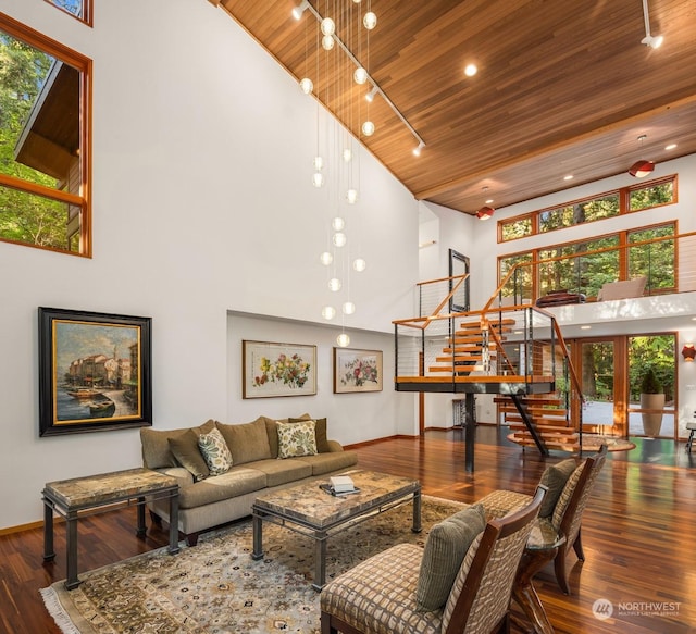 living room featuring track lighting, wooden ceiling, dark hardwood / wood-style floors, and a high ceiling